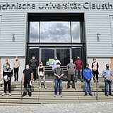 Studierende stehen auf der Treppe vor dem Eingang zum Hauptgebäude der TU Clausthal